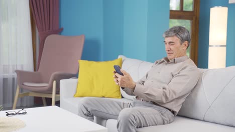 The-Old-Man-is-looking-at-the-phone.-The-old-man-uses-social-media.